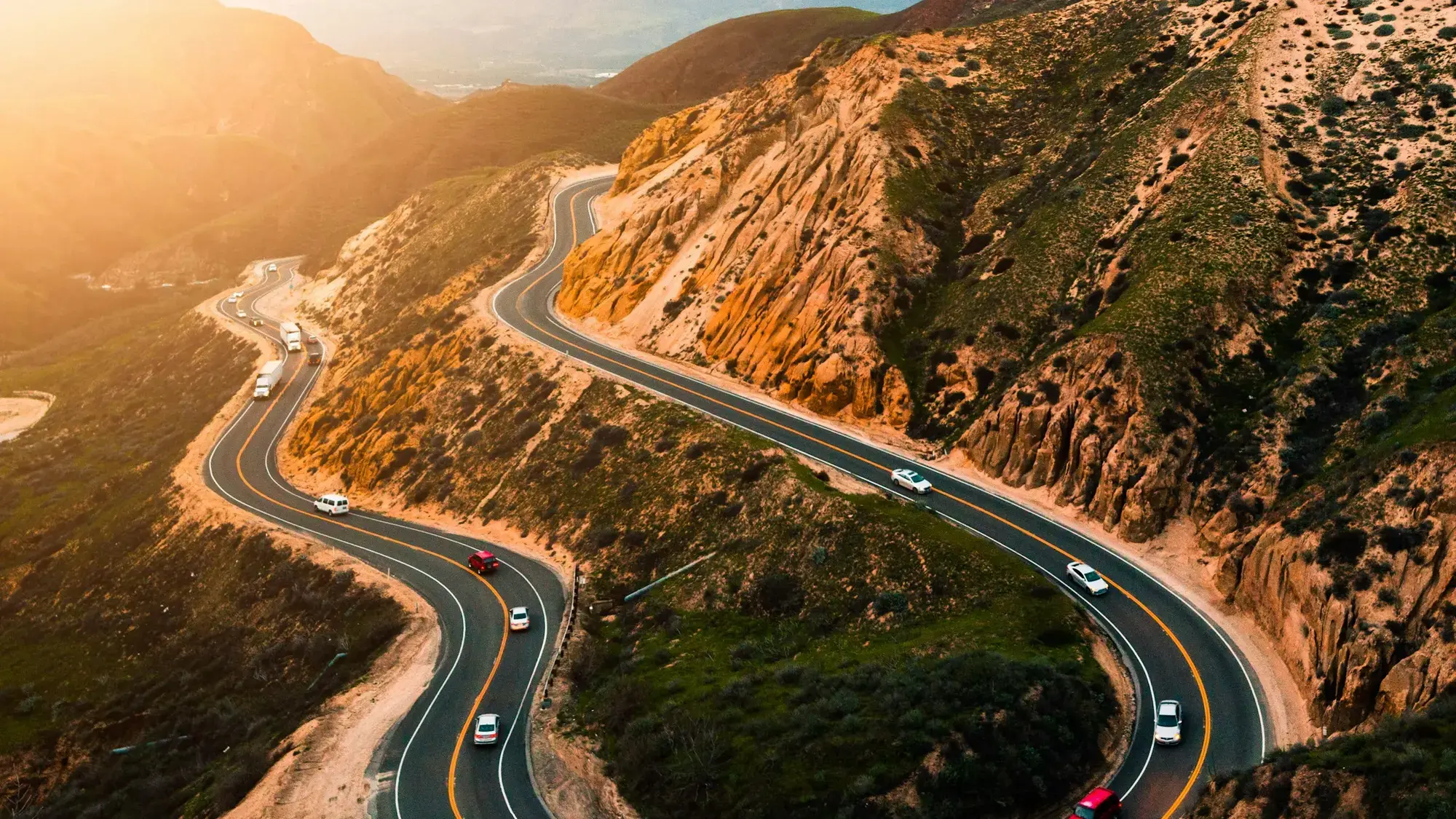 Estrada sinuosa ao pôr do sol, representando liberdade para seguir novos caminhos